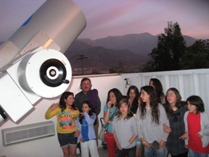 La noche del martes en el Observatorio. El techo y los muros del edificio se abrieron automáticamente para quedar a cielo descubierto. Pablo, el profesor de matemáticas junto a las niñas con el moderno telescopio Goto: observamos Saturno y sus anillos, la Luna y sus cráteres y el cúmulo de estrellas 47 Tucán. calan